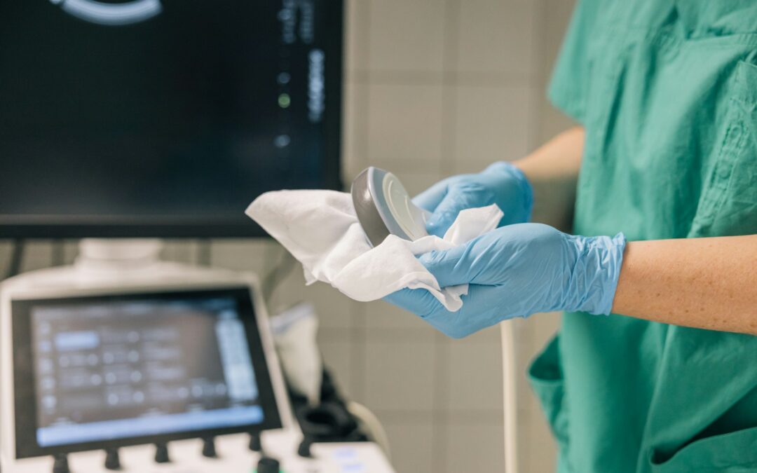 A healthcare professional cleaning the ultrasound head